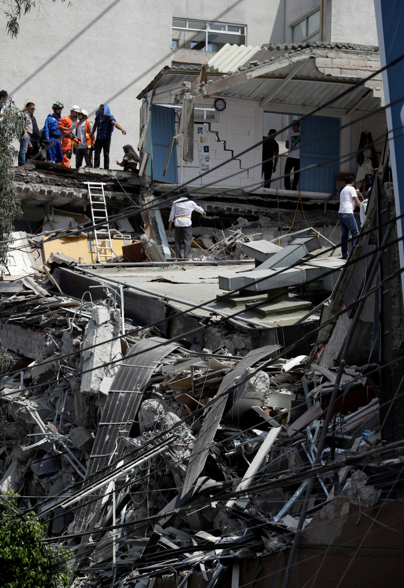 Rescue workers and volunteers search a building that collapsed after an earthquake in downtown Mexico City